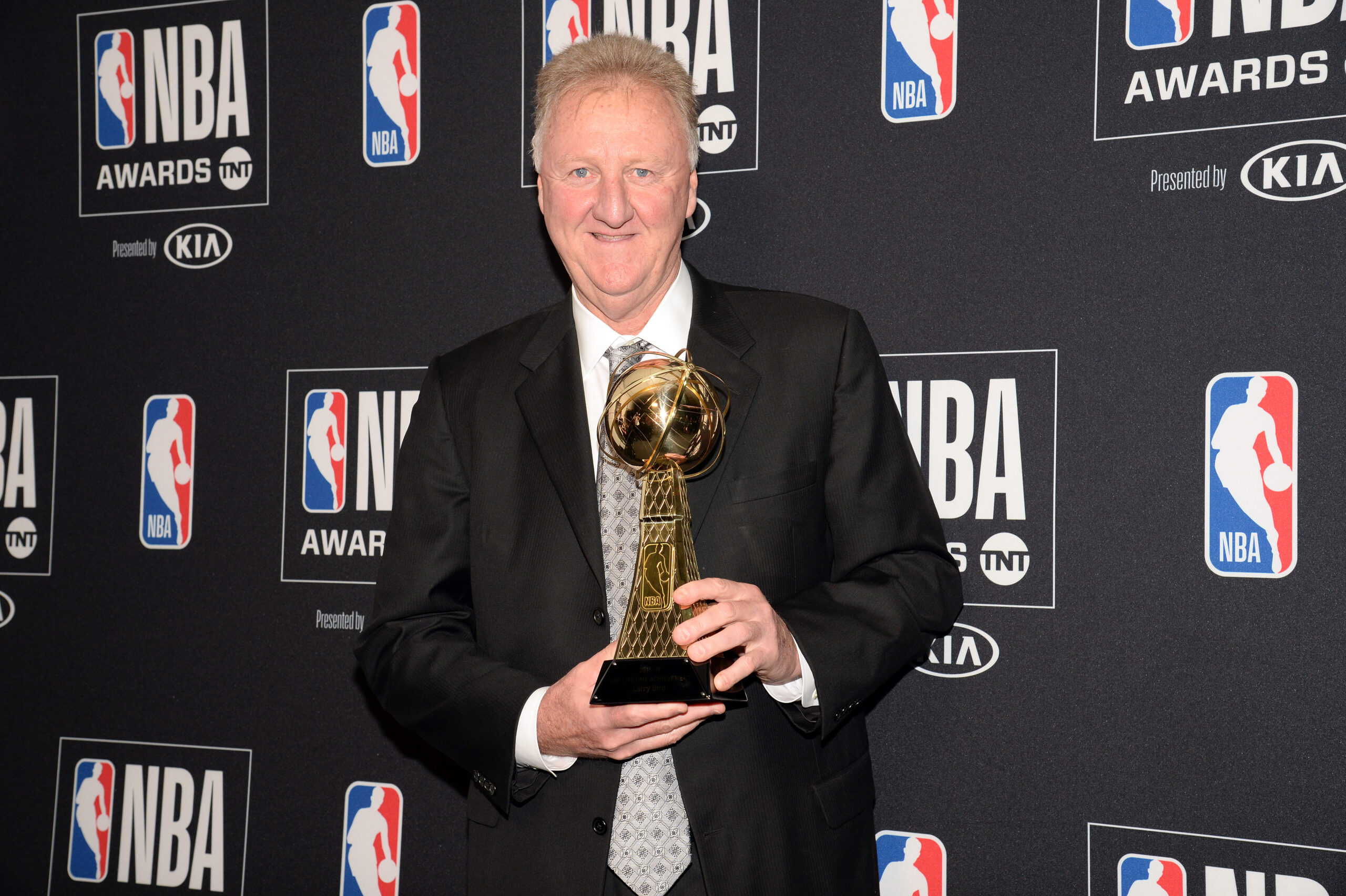 Larry Bird poses with his lifetime achievement award 