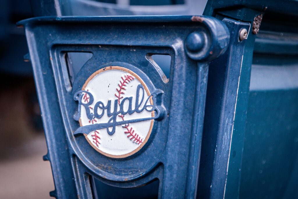 Close-up of a blue plastic mechanism with a circular Royals baseball logo embedded in it.