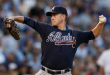 Braves Legend Sends Warning Amid World Series Pursuit Baseball pitcher in a Braves uniform delivering a pitch on the mound.