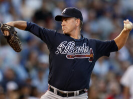 Baseball pitcher in a Braves uniform delivering a pitch on the mound.