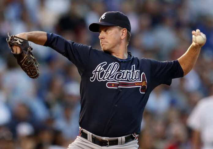 Baseball pitcher in a Braves uniform delivering a pitch on the mound.