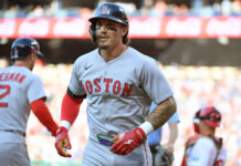 Three Players The Red Sox Could Move Before Trade Deadline Boston Red Sox player wearing helmet and gray uniform with black face paint, on the field during a game.