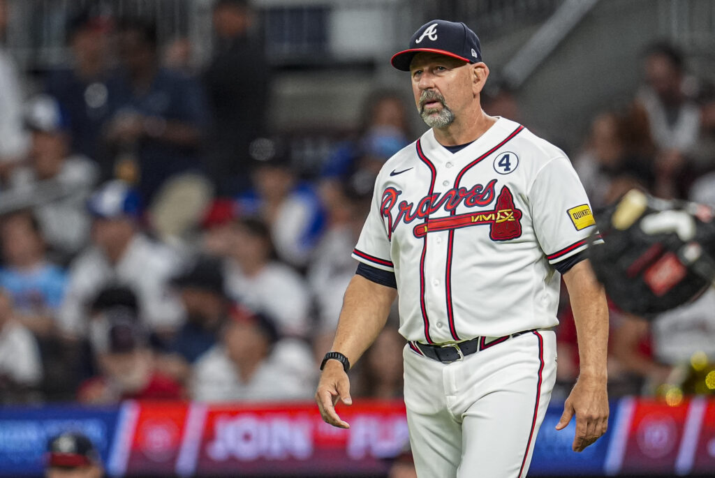 Baseball player in Braves uniform walking on the field during a game, crowd in background.