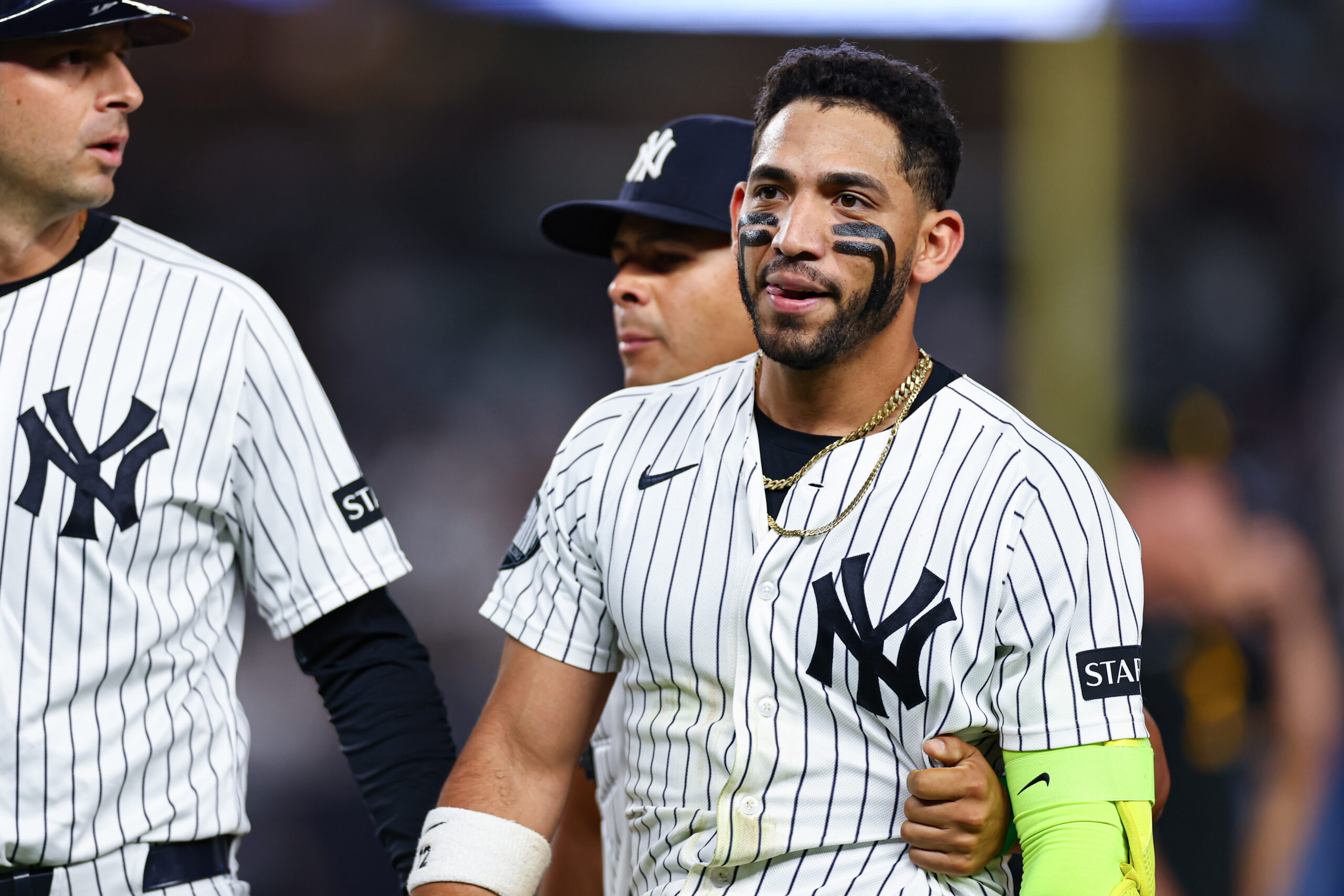 Baseball player in a Yankees pinstripe uniform with black face paint and a gold chain.